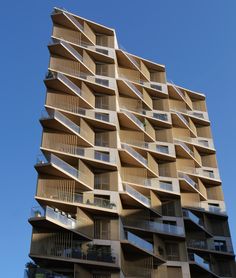 an apartment building with balconies and balconies on the top floor, against a blue sky