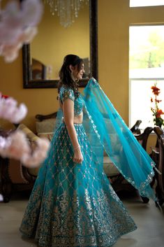 Elevate your beauty with the Magnolias ensemble. Embrace your inner fashionista in this stunning teal Priyanka lehenga adorned with exquisite embroidery and sequins, sure to catch every eye. Pristine elegance meets craftsmanship. A celebration of color and design, the Magnolias ensemble inspires the artist in you. The intricate embroidery and glimmering sequins set you apart, elevating your sense of style with each step. Colour- Teal Fabric & Work Style -- Blouse: Silk with work.- Dupatta: Net d Designer Turquoise Lehenga With Cutdana, Semi-stitched Bollywood Lehenga In Turquoise, Designer Turquoise Embroidered Lehenga, Luxury Embroidered Turquoise Lehenga, Turquoise Lehenga, Indian Bridal Couture, Fabric Work, Blouse Silk, Teal Fabric