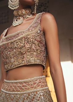 The embellished Gold Lehenga Choli Pakistani Wedding Dress in Ivory is effortlessly snappy and fun with the essence of pop. Bridal Choli: Introducing the Nikah outfit for the happiest bride. Starting the outfit with an astonishing blouse having silver embroidery which includes kora, dabka, tilla, and Kundan to make this outfit a unique piece of fun. Further, it is enhanced with boat shape neckline with intimate full sleeves. Gold Lehenga: It is beautifully organized with a can-can lehenga in the Bollywood Style Sharara With Pearl Embroidery For Reception, Wedding Embellished Sets For Diwali, Embellished Wedding Sets For Diwali, Bollywood Pearl Embroidered Choli For Reception, Bollywood Choli With Pearl Embroidery For Reception, Bollywood Style Choli With Pearl Embroidery For Receptions, Wedding Choli With Pearl Embroidery And Traditional Drape, Embellished Sets For Wedding And Festivals, Embellished Wedding Sets For Festivals