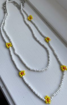 PAINTMOB PRESENTS: Trendy and beautiful minimalist 2 piece yellow and white flower necklaces for daily use. My necklaces can go with any clothing item and bring out any outfit/layering piece! Handmade jewelry with love and care from Canada. It is a perfect summer & spring accessory! CARE  The necklace is handmade by me and may vary a little from the photos. I do try my best to ensure durability, however, handling the jewelry with care is always a good idea to making them last. PRODUCTION TIMES A Flower Beaded Necklace, Outfit Layering, Flower Necklaces, Spring Accessories, Fishing Line, Mail Letters, Flower Necklace, White Flower, 2 Piece Set