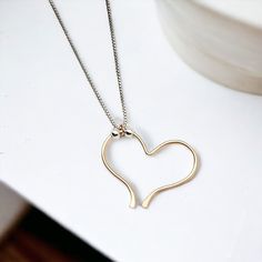 Indulge in the timeless elegance of our Open Heart Necklace. The delicate sterling silver chain is home to a handcrafted gold open heart charm, adorned with shimmering silver beads. Exquisitely combining luxury and sophistication, this necklace is a must-have for any wardrobe. Sterling Silver Chain Adjustable Lenth from 15" - 18" Handmade 14k Gold Filled Open Heart Charm Sent in a Ribboned Gift Box with Polishing Cloth Handmade in Montana Gold Heart Necklace With Box Chain, Minimalist Everyday Heart Necklace With Adjustable Chain, Minimalist Gold Necklace With Heart Beads, Heart Charm Pendant Necklace For Everyday, Everyday Yellow Gold Heart Necklace In Sterling Silver, Everyday Heart Charm Pendant Necklace, Dainty Heart Necklace With Adjustable Chain For Everyday, Everyday Heart Pendant Charm Necklace With Delicate Chain, Gold Minimalist Heart Beads Necklace