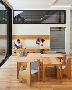 two children are playing with toys in the dining room table and chair set that is made from wood