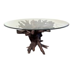 a glass and wood table with branches on the base, against a white background that appears to be made from driftwood