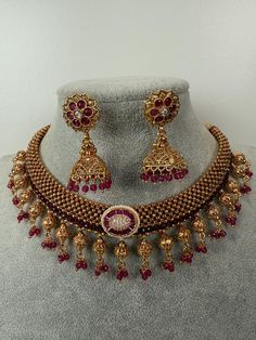 This exquisite piece of craftsmanship comes from our Traditional collection. Finish: 24 grams gold finish Necklace Fastening: Adjustable Dori  Perfect for Indian weddings. Earring jhumka Fastening: Push Back Contains: 1 necklace, 1 pair of earrings Luxury Temple Jewelry Chandbalis For Diwali, Luxury Temple Necklace For Diwali, Luxury Temple Jewelry Danglers For Celebrations, Gold Chandbali Temple Jewelry Necklace, Gold Plated Tilla Temple Jewelry, Bridal Choker Necklace With Intricate Design For Celebration, 22k Gold Bridal Necklace With Latkans, Gold Round Temple Necklace With Meenakari, 22k Gold Chandbali Necklace As Gift