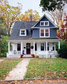 a white and blue house in the fall