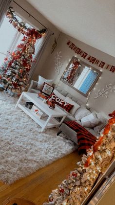 the living room is decorated for christmas with red and white decorations on the walls, along with a large tree