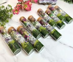 there are many different types of flowers in the glass tubes on the table with each other