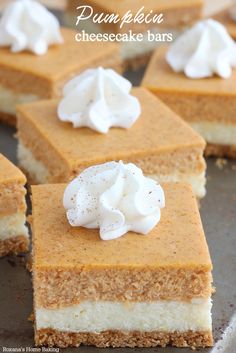 pumpkin cheesecake bars with whipped cream on top are sitting on a baking sheet and ready to be eaten