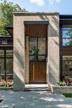 the front entrance to a modern home with large windows