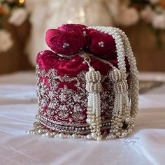 Indulge in timeless elegance with our exquisite bridal potli bag, meticulously crafted in deep red velvet to capture the essence of luxury and tradition. Designed with South Indian brides in mind, this opulent accessory is adorned with intricate dabka, beadwork, sparkling stones, and shimmering sequins, ensuring a mesmerizing entrance on your special day. Elevate your bridal ensemble with this stunning potli bag, a symbol of sophistication and grace. Product Details: *Handmade with traditional Pakistani and Indian techniques *Spacious interior  *Measures 6 inches To explore additional styles, kindly visit our website at dulhansdiary.etsy.com. . . . . . . #silverpotlibag #handmadeclutch #bridalhandbag #weddingaccessories #ethnicbag #uniquegift #artisanmadeclutch #punjabiclutches #potlibag # Hand Bag For Bride, Bridal Bag For Wedding Day Indian, Bride Purse Wedding Day, Red Shoulder Bag For Festive Gift, Festive Red Shoulder Bag As Gift, Festive Red Shoulder Bag For Gifts, Luxury Festive Bags With Pearl Handle, Red Shoulder Bag For Festivals As Gift, Red Shoulder Bag For Festivals And Gifts