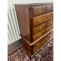 a wooden dresser sitting on top of a rug