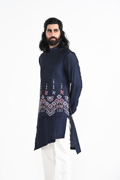 Navy Phulkari inspired Nehru Jacket with pipe, cutdaana and thread work embroidery with overlapping kurta highlighted with embroidery detail on the chest and stitchline border made in Bamberg Raw Silk. Paired with Ivory slim fit Pant Pajama. Color of the actual garment may vary due to lighting conditions during the shoot.
 

Size Chart For Men





	
	
					Men's Size Chart
		

		
		
						
				Size Chart For Men
				Custom Size Measurement Guide
			
			
				
				
				Custom Size Measurement Gui Embroidered Bandhgala In Chanderi Fabric, Designer Floral Embroidery Kurta For Transitional Season, Designer Floral Embroidered Kurta For Transitional Season, Traditional Drape Nehru Jacket With Floral Embroidery, Designer Raw Silk Nehru Jacket With Floral Embroidery, Traditional Drape Kurta With Floral Embroidery For Eid, Floral Embroidered Kurta With Traditional Drape For Eid, Floral Embroidered Kurta For Eid With Traditional Drape, Floral Embroidery Kurta With Traditional Drape For Eid