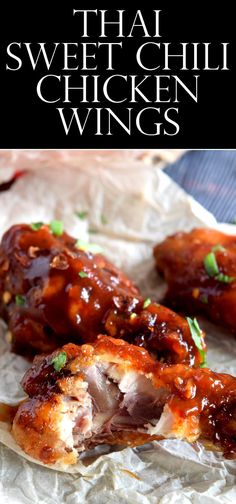 some chicken wings with sauce and parsley on top, sitting on wax paper in front of the words thai sweet chilli chicken wings