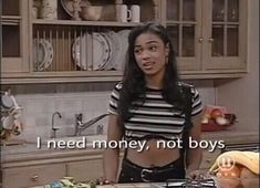 a woman standing in a kitchen next to a counter with food on it and an ad that says i need money, not boys