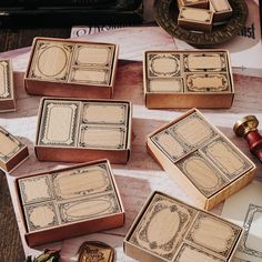 several wooden boxes sitting on top of a table next to some ink pens and paper