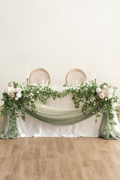 the table is set up with two chairs and some flowers on it, along with candles