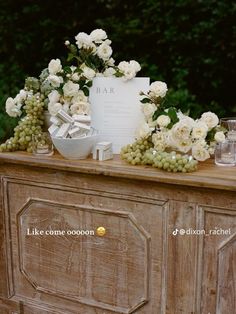 a table topped with white flowers and greenery