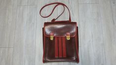 Retro leather shoulder bag, in brown and red color. Produced in 1980, the bag has three internal compartments - one large main compartment and two smaller ones. Used but in very good condition, no tears or missing or damaged parts. Suitable for carrying books, documents, a tablet or a small laptop. Approximate sizes:  Length: 27 cm (10.6 in.) Width: 9 cm (3.5 in.) Height: 33 cm (13 in.) Weight: 753 grams All photos are real. You buy what see on the photos We only offer vintage items that almost always have some type of wear and tear such as scratches, cracks, missing paint, corrosion and more. These imperfections only add style to the retro appeal. We always try to describe and show pictures of any damage or wear. Please review the photos carefully as part of the product description. Your Vintage Leather Shoulder Backpack For School, Brown Rectangular Shoulder Bag For Students, Red Laptop Satchel Bag, Retro Leather Backpack Shoulder Bag, Retro Leather Backpack-style Shoulder Bag, Retro Brown Leather Backpack For School, Retro Brown Leather School Backpack, Vintage Brown Leather School Backpack, Rectangular Leather Backpack For School