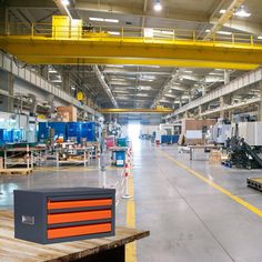 the inside of a large warehouse with lots of machines and boxes on tables in front of them