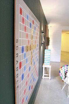 a scrabble board is on the wall next to a chair