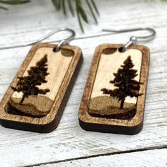 two wooden earrings with trees on them