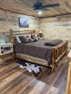 a rustic bedroom with wooden walls and flooring