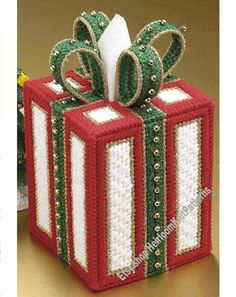 an ornament wrapped present box with ribbon and bow