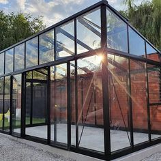 a glass house with the sun shining through it