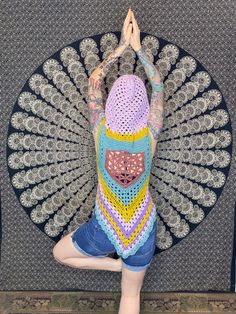 a woman is doing yoga in front of a wall with an intricate design on it