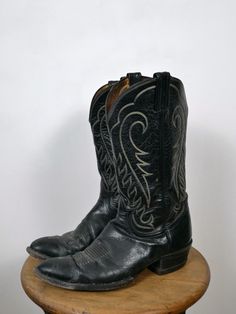 Vintage Tonny Lama Men's  Black Leather Cowboy Boots. Measurements( All measurements are taken in OUTSOLE, NOT INSOLE) Tagged size              : 11 1/2B Length(heel to toe) : 11 1/2" Width                         : 3 1/2" Shaft                          : 12 1/2" Shaft Circumfence  : 14 1/2" Heel                           : 1 1 /2" Condition                 : Gently used. There's  a small rip on back as shown in the last pic. Inside of the boots opening is slightly discolored and dried. Good con Vintage Black Plain Toe Boots, Rugged Black Work Boots For Western-themed Events, Black Rugged Work Boots For Western-themed Events, Fitted Vintage Boots With Goodyear Welted, Vintage Moto Boots With Goodyear Welt And Snip Toe, Fitted Vintage Boots With Goodyear Welt, Fitted Vintage Black Boots, Vintage Black Moto Boots With Snip Toe, Vintage Boots With Reinforced Cap Toe