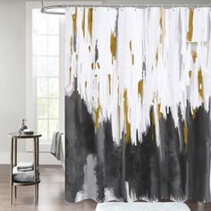 a shower curtain with black and gold paint on it