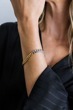 Featuring a striking blend of gold and silver, the mixed metal cuban link chain bracelet creates a bold and contemporary look. Its durable construction and eye-catching design make it the perfect statement piece to elevate any outfit.- Stainless steel base - Length: 7" / 177.8mm (one size fits most) - Width: 0.24" / 6mm- Lobster clasp- Available in mixed-metal- Engraved with signature MC branding- Hypoallergenic, non-tarnish, water-resistant Modern Chunky Chain Cuban Link Bracelets, Modern Bracelets With Chunky Cuban Link Chain, Modern Chunky Cuban Link Chain Bracelet, Gold Cuban Link Metal Bracelet, Modern Cuban Link Gold Chain Bracelet, Modern Curb Chain Link Bracelet, Trendy Cuban Link Bracelet With Curb Chain, Modern Cuban Link Chain Bracelet With Solid Construction, Modern Gold Bracelet With Curb Chain