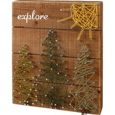 a wooden box with string wrapped christmas trees on it and the word explore written in white