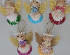 four angel ornaments are hanging on the wall