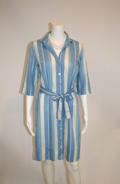 "Cotton shirtdress by John of California in stripes of blues, lavender, and off white.  Loose belt Mother of pearl buttons Size: no tag Measures laying flat: 18.5\" armpit to armpit, 18.5\" waist, 38\" shoulder to hem Condition: Good Vintage Condition" Chic Summer Shirt Dress With Vertical Stripes, Fitted Shirt Dress With Tie Waist For Spring, Spring Shirt Dress With Striped Collar, Striped Buttoned Shirt Dress For Summer, Striped Shirt Dress With Buttons For The Beach, Striped Shirt Dress With Buttons For Summer, Striped Belted Dress For Summer, Spring Daywear Shirt Dress With Striped Collar, Striped Summer Shirt Dress With Button Closure