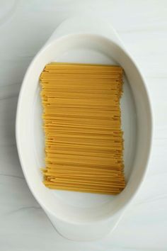 a white bowl filled with pasta on top of a table