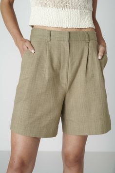 Want to look elegant and show a bit of leg? Discover the Bièl shorts in Sage Green. These shorts feature a high and slim fit at the waist, with a relaxed fit in the leg. They include a double pleat and two side pockets. The Bièl shorts are perfect for the warmer summer days, but also look stunning in the winter when paired with tights and boots. Complete your look with the matching June Jacket.The fabric is a mix of organic and recycled cotton. The yarns are traditionally plant dyed with red onions in India and then handwoven into a beautiful fabric, giving it a natural look and ensuring its uniqueness. The production is carried out by a family-owned business in Portugal.Size & FitFits true to size. Our model is 177cm (5 feet 9.7 inches) and wears size S. Material & CareThe fabric of the B Classic Bermuda Shorts With Built-in Shorts, Green Workwear Shorts With Belt Loops, Solid Color Shorts For Summer Workwear, Green High-waisted Shorts For Work, High-waisted Green Shorts For Work, Chic Bermuda Shorts With Belt Loops, Classic High-waisted Shorts With Belt Loops, High-waisted Bermuda Shorts For Work, Fitted Pleated Waist Shorts For Work