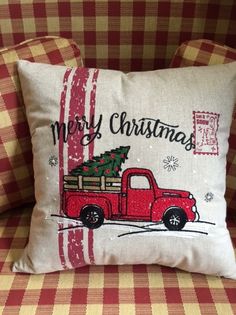 a red truck with a christmas tree on the back is sitting on a plaid couch