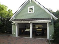 a garage with two cars in it and one door open to the other side,