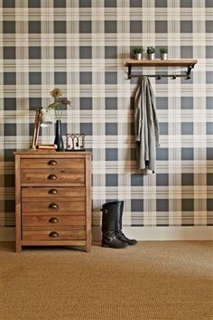 a wooden dresser sitting in front of a wall with plaid pattern on it's walls