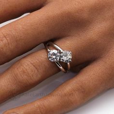 a woman's hand with two engagement rings on it