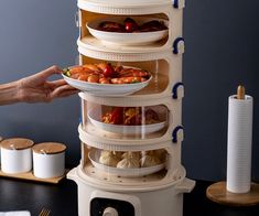 a person holding a plate with food on it in front of a stack of plates