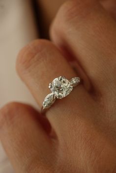 a woman's hand with a diamond ring on it