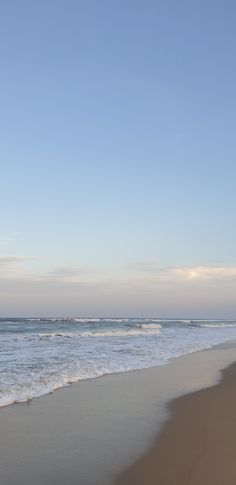 two people walking on the beach with surfboards