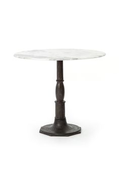 a white marble table with an iron base and round pedestal, on a white background