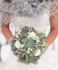 a bride holding a bridal bouquet with succulents