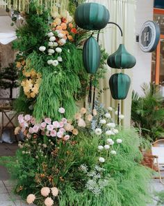 an arrangement of flowers and plants in front of a building