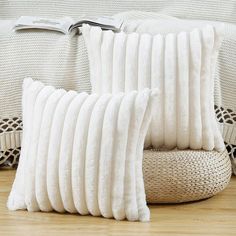 two white pillows sitting on top of a wooden floor