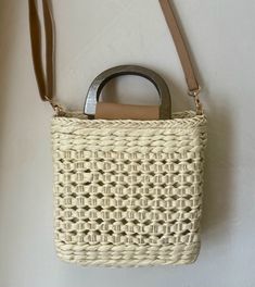 Our Ibiza straw crochet handbag is the perfect addition to your spring/summer wardrobe! This lightweight tote is a must for vacation! Lightweight Straw Woven Handbag Top handles and straps Materials: 100% Paper Straw Drawstring Opening-Polyester Lining Imported Approximately: 7x7.8 in Square Cream Straw Bag For Summer, Summer Cream Square Straw Bag, Cream Square Straw Bag For Summer, White Square Bucket Bag For The Beach, White Square Bucket Bag For Beach, Summer Braided Natural Bucket Bag, Braided Natural Bucket Bag For Summer, Summer Braided Jute Bucket Bag, Natural Braided Bucket Bag For Summer