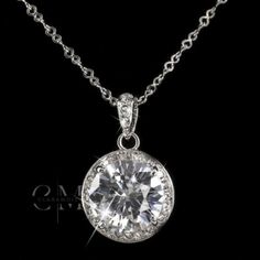 a necklace with a large diamond on the front and side, hanging from a chain